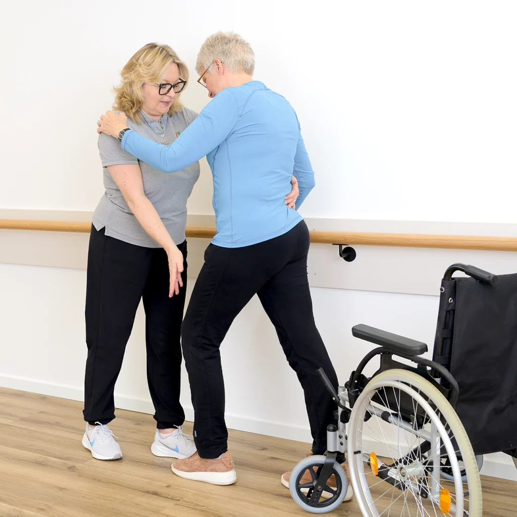 Unterstützung bei Gehübungen einer Patientin.