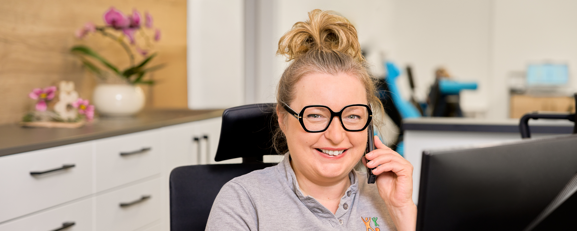 Die Praxisinhaberin Domicela Knieps lacht in die Kamera und telefoniert.