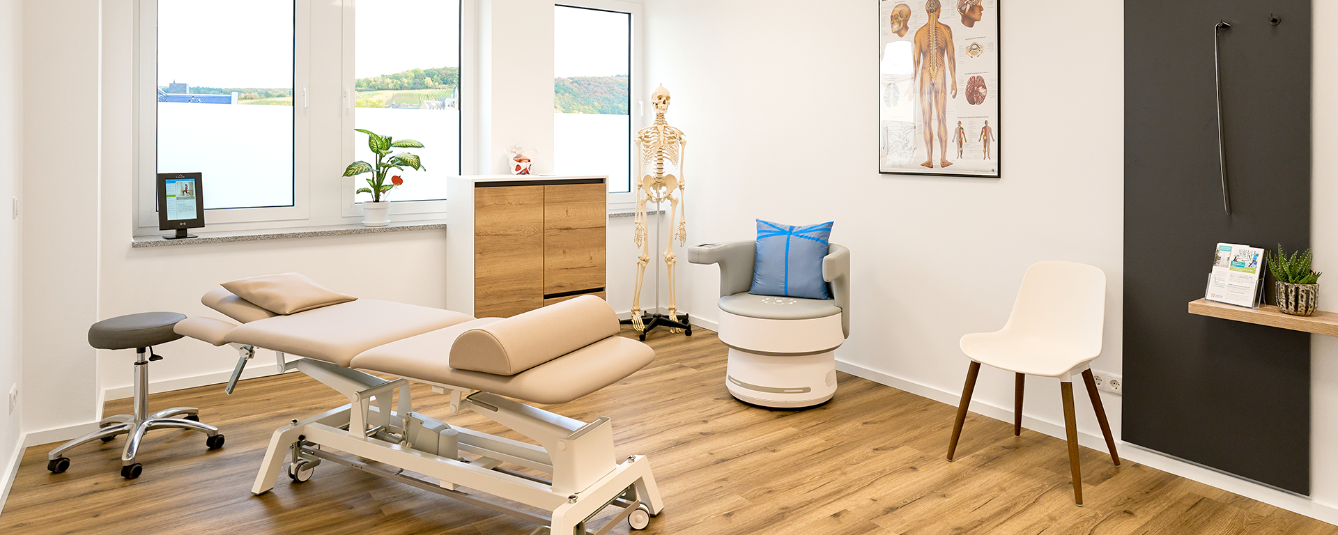 Therapieraum mit Behandlungsliege und EMR-Stuhl